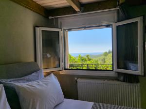 a bedroom with a bed and a window with a view at Sogno 1 in Parga