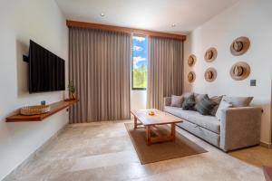 a living room with a couch and a tv at New Hotel Serenata Santa Lucia Mérida in Mérida