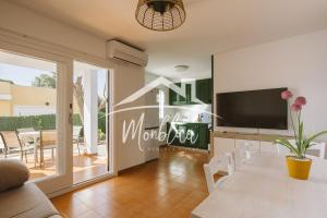a living room with a television and a table with chairs at Sa Torreta 1 in Cala Blanca