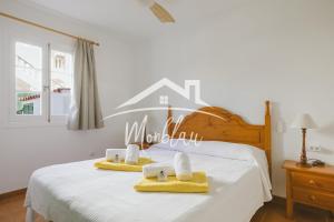 a bedroom with a bed with yellow towels on it at Sa Torreta 1 in Cala Blanca +19 photos