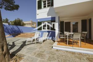 a patio with chairs and a table in front of a house at Sa Torreta 1 in Cala Blanca