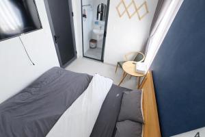 a small bedroom with a bed and a mirror at Hello Dalat Hostel in Da Lat