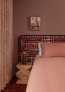 a bedroom with a bed with a wooden headboard at Bon Bon Apt 2 - Rosa in Orange