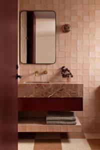 a bathroom with a sink and a mirror at Bon Bon Apt 2 - Rosa in Orange
