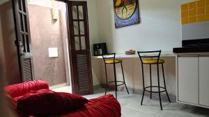 a living room with a couch and two bar stools at Funcional, cômoda e confortável in Camaçari