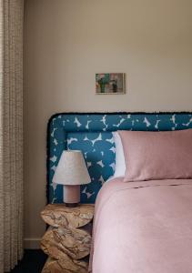 a bedroom with a bed with a blue headboard and a lamp at Bon Bon Apt 5 - Tonka in Orange