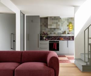 a living room with a red couch and a kitchen at Bon Bon Apt 4 - Roca in Orange