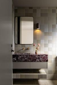 a bathroom with a mirror and a vase of flowers at Bon Bon Apt 4 - Roca in Orange
