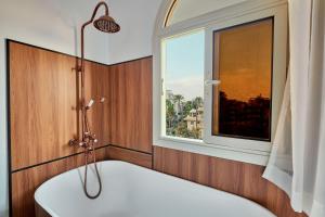 a bath tub in a bathroom with a window at Palmeras Pyramids Hotel in Cairo +53 photos