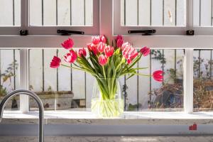 a vase of pink flowers sitting on a window sill at Woodlodge Retreat in Holywood +33 photos