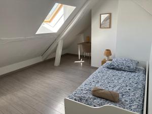 a white room with a bed and a staircase at Le cocon des Quais in Auxerre
