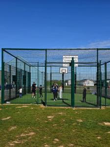 a group of people standing behind a batting cage at Loulex Deluxe in Jaywick Sands