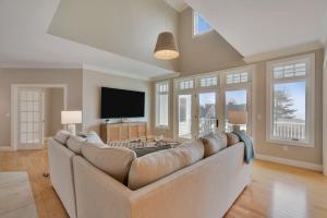 a living room with a large couch and a tv at The Hill Dog Friendly Panoramic Ocean Views in York