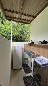 a kitchen with a white refrigerator and a sink at Sítio Pereira in Paraty