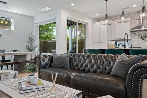 a living room with a leather couch and a kitchen at Spacious 5BR Central Austin Home Sleeps 13 in Austin +67 photos