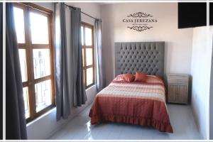 a bedroom with a bed in a room with windows at Casa Jerezana Hotel Boutique in Jerez de García Salinas