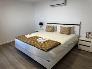 a bedroom with a large bed with towels on it at Hiking & Ocean in Arco da Calheta