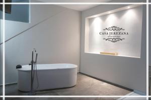 a white bathroom with a tub and a sign on the wall at Casa Jerezana Hotel Boutique in Jerez de García Salinas