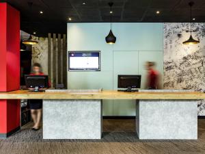 a lobby with a counter with two computers on it at Ibis Szczecin Centrum in Szczecin
