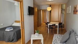 a small room with a bed and a dining room at PASEO ROMANo in Lugo