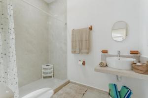 a white bathroom with a sink and a shower at Hermoso DEPARTAMENTO En El Centro Y Corazon DE CANCUN in Cancún +15 photos