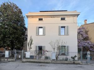 a white house with a fence in front of it at B&B Glicine in Civitanova Marche