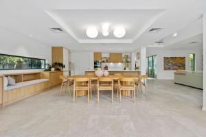 a kitchen and dining room with a table and chairs at Luxe on North Point in Kingscliff