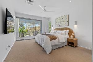 a bedroom with a large bed and a large window at Luxe on North Point in Kingscliff +26 photos