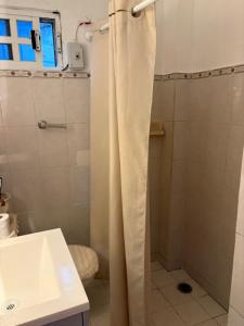 a bathroom with a shower curtain and a sink at Majen Nah in Progreso
