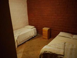 a room with two beds and a brick wall at Luz da Serra Hospedagens in Santana do Riacho