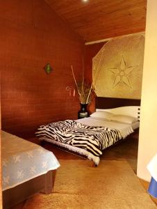 a bedroom with a zebra print bed in a room at Luz da Serra Hospedagens in Santana do Riacho