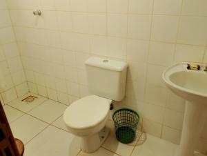 a bathroom with a toilet and a sink at Luz da Serra Hospedagens in Santana do Riacho