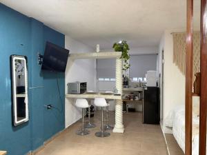 a kitchen with a counter and stools in a room at Majen Nah in Progreso