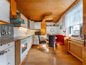 a kitchen with wooden ceilings and a red couch at Madreit in Leogang