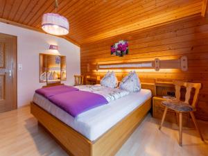 a bedroom with a bed and a wooden wall at Madreit in Leogang