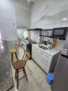 a kitchen with two chairs and a stove top oven at Aconchego do Caju in Arraial do Cabo +38 photos