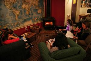 a group of people sitting in a room with a fireplace at Tasman Bay Backpackers in Nelson