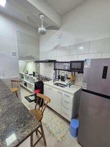 a kitchen with a refrigerator and a counter top at Aconchego do Caju in Arraial do Cabo
