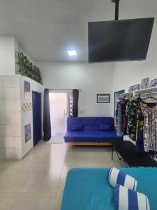 a living room with a blue couch and a tv at Aconchego do Caju in Arraial do Cabo