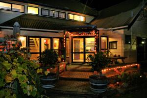 una casa con patio por la noche con luces en Tasman Bay Backpackers en Nelson