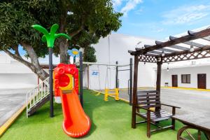 a playground with an orange slide and a bench at Hotel H4 El Paraíso in El Paraíso