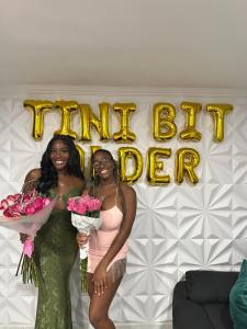 two women standing in front of a happy birthday sign at Private Paradise bk in Brooklyn