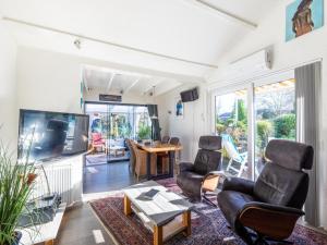 a living room with chairs and a tv and a table at Wadjuweel in Lauwersoog