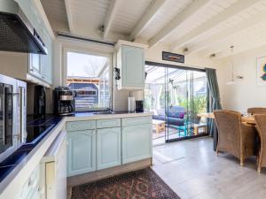 a kitchen with blue cabinets and a table and chairs at Wadjuweel in Lauwersoog