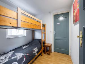 a bedroom with a bunk bed and a blue door at Wadjuweel in Lauwersoog