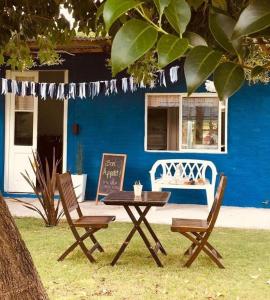 a picnic table and two chairs in front of a blue house at La Posada del Sol in Torres