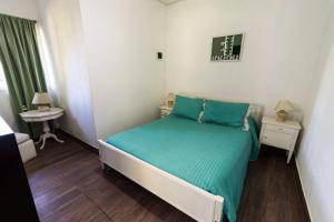 a small bedroom with a bed with a green comforter at La Posada del Sol in Torres +40 photos