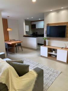 a living room with a couch and a flat screen tv at Apto 2 Quartos Novo e Super Confortável in Arapiraca