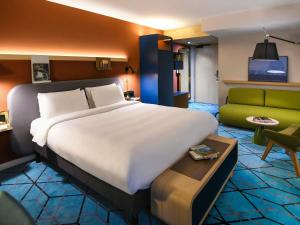 a hotel room with a large bed and a couch at Mercure Nantes Centre Gare in Nantes +103 photos