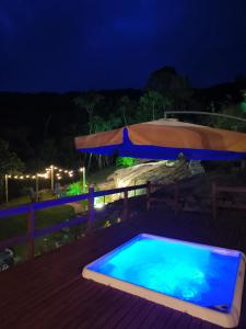 a swimming pool on a deck at night at Cabana Recanto Dona Ilza in Biguaçu